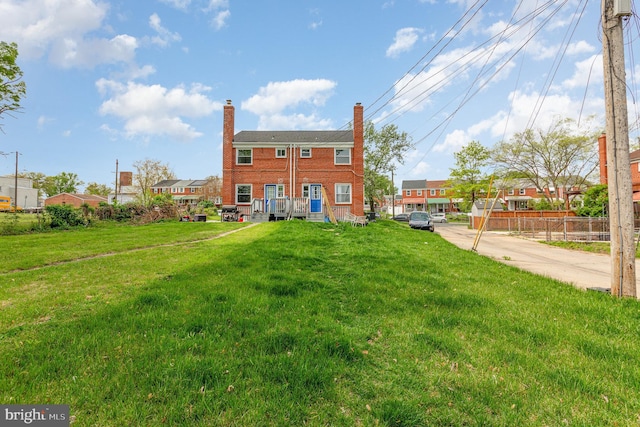 back of property with a lawn, fence, and a chimney