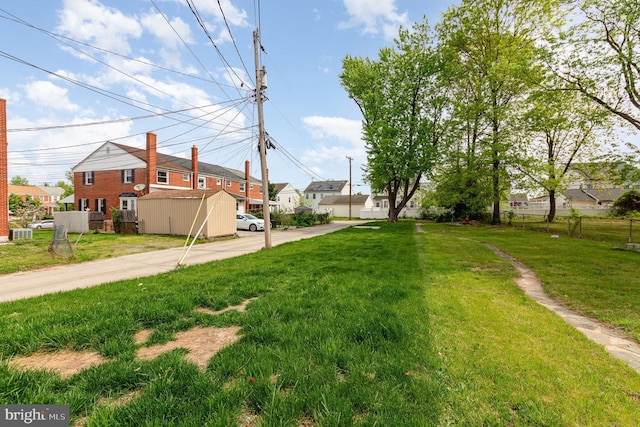 view of yard featuring fence, cooling unit, and a residential view