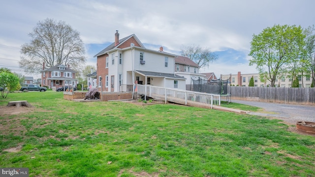 718 Walnut St, Royersford, PA 19468 - rear view of house with a trampoline, a deck, and a chimney