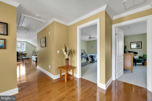 corridor with attic access, wood finished floors, visible vents, and baseboards
