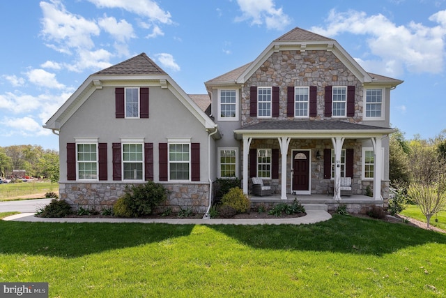 view of front of house featuring covered porch, stucco siding, a front lawn, and stone siding