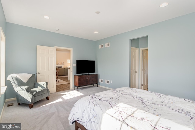 bedroom with baseboards, light carpet, recessed lighting, and visible vents