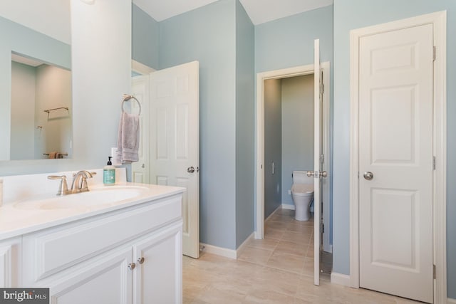 bathroom with vanity, baseboards, and toilet