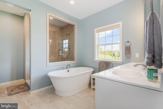 full bath with baseboards, a freestanding tub, a stall shower, and vanity
