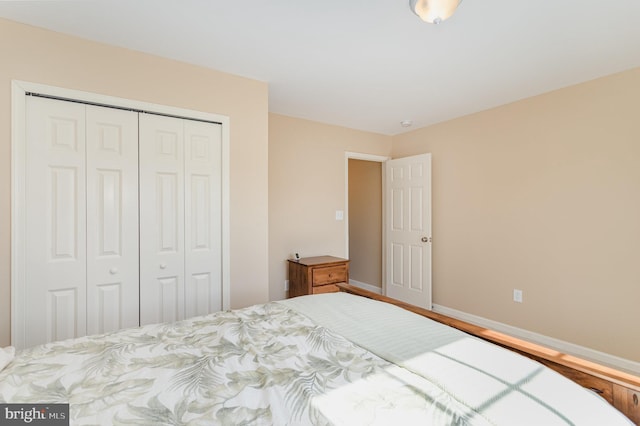 bedroom featuring a closet, baseboards, and wood finished floors
