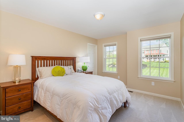 bedroom featuring baseboards and light colored carpet