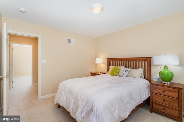 bedroom featuring baseboards, light carpet, and visible vents