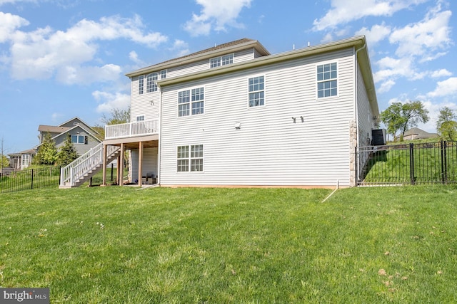 rear view of house with a yard, a wooden deck, stairs, and a fenced backyard