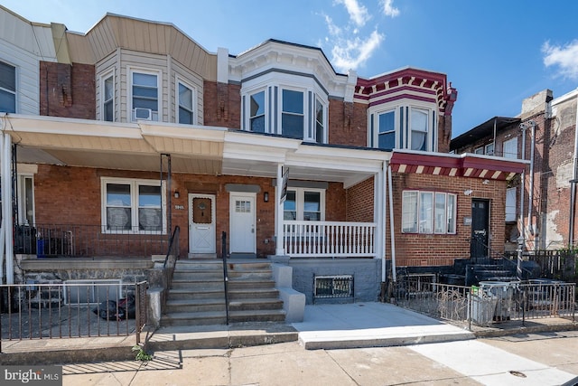 multi unit property with brick siding, fence private yard, and covered porch