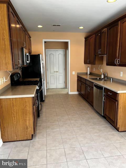 1402 Joppa Forest Dr Unit 12, Joppa, MD 21085 - kitchen with light countertops, a sink, appliances with stainless steel finishes, and light tile patterned floors