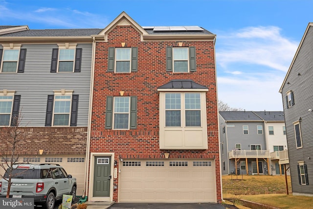 9008 Waller Tree Way, Upper Marlboro, MD 20772 - townhome / multi-family property with a garage, brick siding, aphalt driveway, and roof mounted solar panels