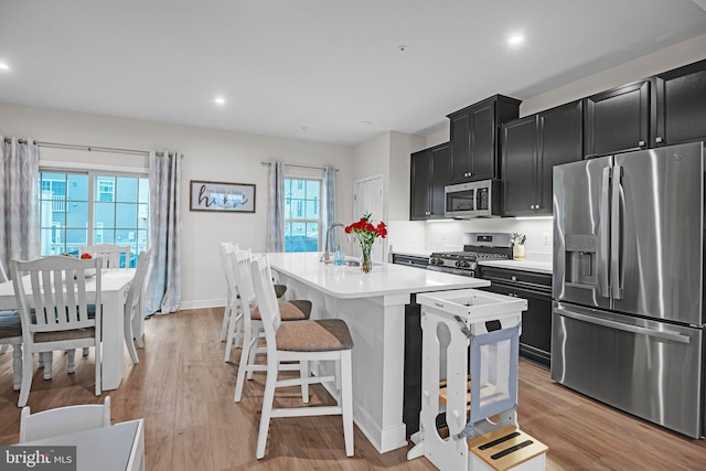 9008 Waller Tree Way, Upper Marlboro, MD 20772 - kitchen featuring dark cabinets, appliances with stainless steel finishes, light countertops, a sink, and a center island with sink