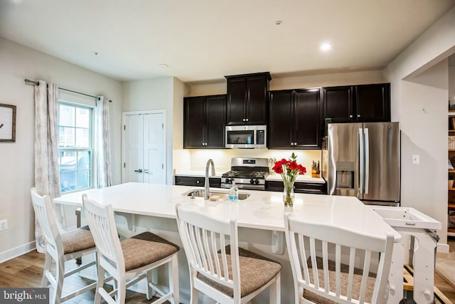 9008 Waller Tree Way, Upper Marlboro, MD 20772 - kitchen with a sink, appliances with stainless steel finishes, light countertops, light wood-type flooring, and a kitchen island with sink