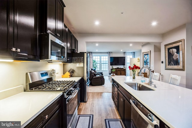9008 Waller Tree Way, Upper Marlboro, MD 20772 - kitchen with light wood-style floors, appliances with stainless steel finishes, light countertops, a sink, and open floor plan