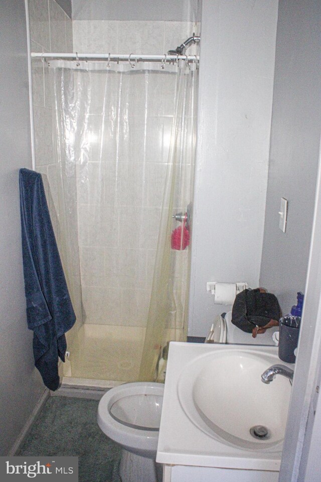 full bathroom featuring toilet, a stall shower, and a sink