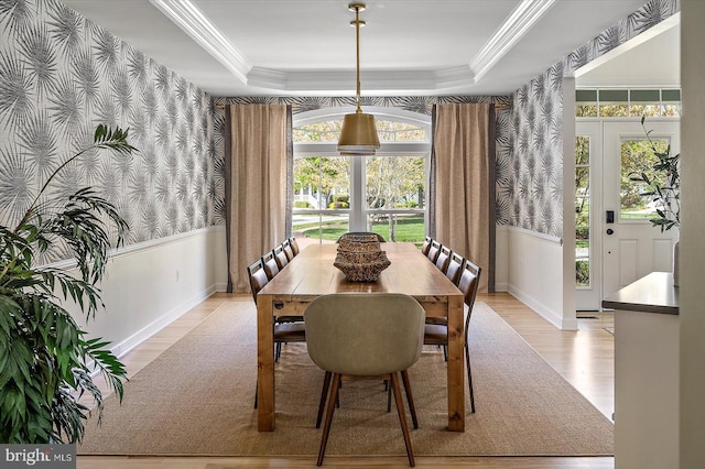 dining room featuring baseboards, wallpapered walls, a healthy amount of sunlight, and light wood-type flooring