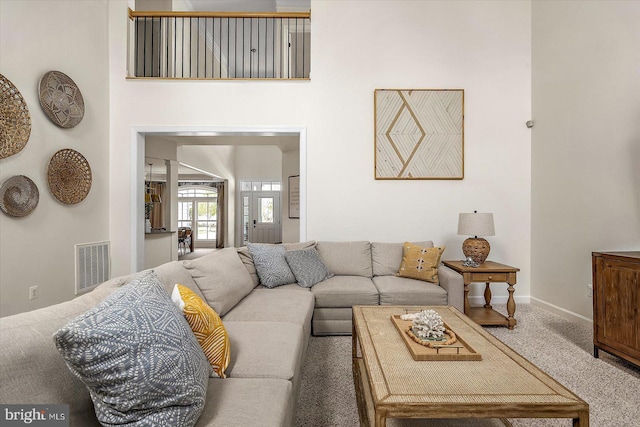 living room featuring visible vents, carpet flooring, and baseboards