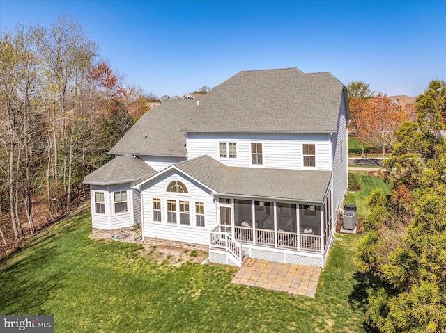 back of property with roof with shingles, a lawn, a sunroom, and cooling unit
