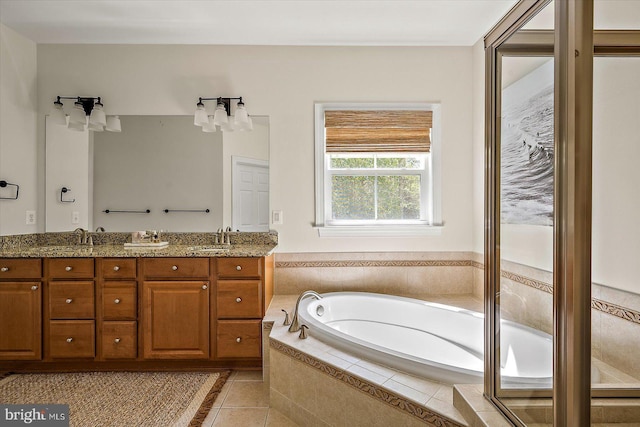 bathroom with a sink, tile patterned floors, double vanity, and a bath