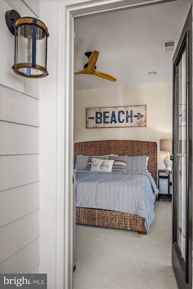 carpeted bedroom with visible vents and ceiling fan