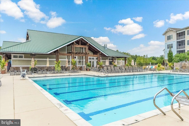 community pool with a patio and fence