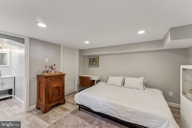 bedroom featuring baseboards and light wood finished floors