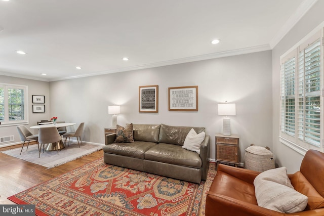 living area featuring crown molding, recessed lighting, baseboards, wood finished floors, and visible vents