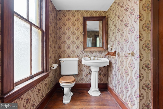 bathroom with a healthy amount of sunlight, baseboards, toilet, and hardwood / wood-style flooring