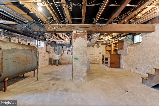 unfinished below grade area with a sink and heating fuel