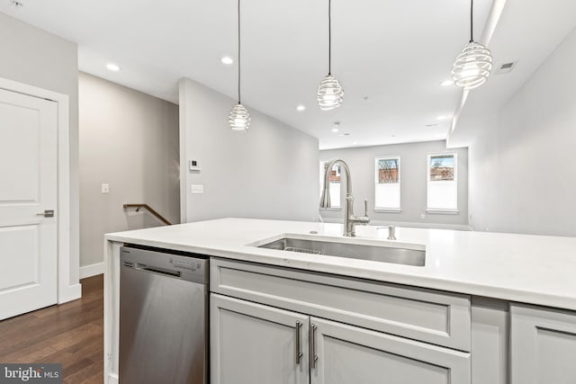 kitchen featuring dishwasher, light countertops, a sink, and dark wood-type flooring
