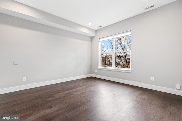 unfurnished room featuring recessed lighting, dark wood finished floors, visible vents, and baseboards
