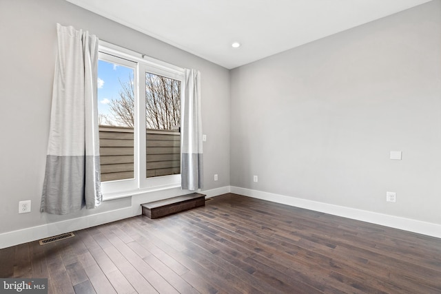 unfurnished room featuring dark wood-style floors, baseboards, visible vents, and recessed lighting