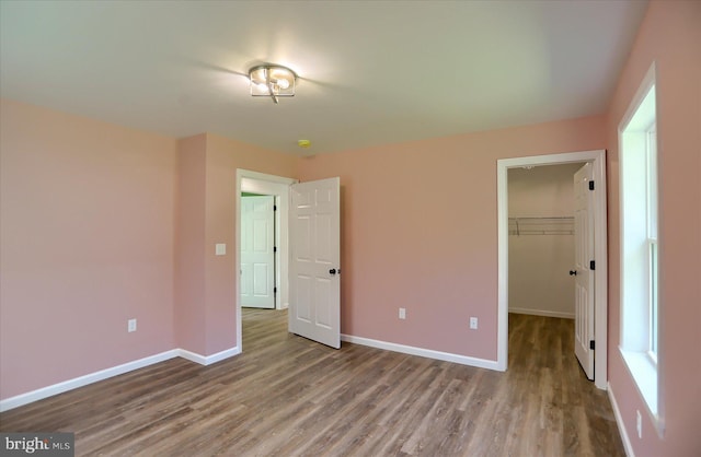 3497 New Lancaster Valley Rd, Milroy, PA 17063 - unfurnished bedroom featuring wood finished floors, a closet, a walk in closet, and baseboards