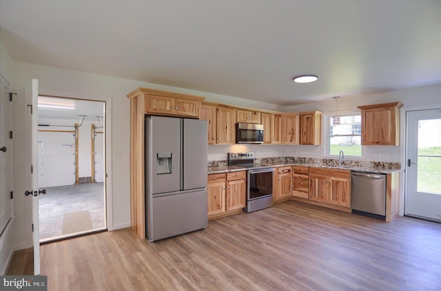 3497 New Lancaster Valley Rd, Milroy, PA 17063 - kitchen with appliances with stainless steel finishes, light stone counters, light wood-type flooring, and a sink