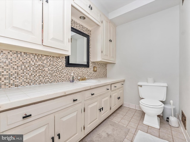 23 E Wheeling St, Baltimore, MD 21230 - bathroom with tile patterned flooring, toilet, vanity, baseboards, and decorative backsplash