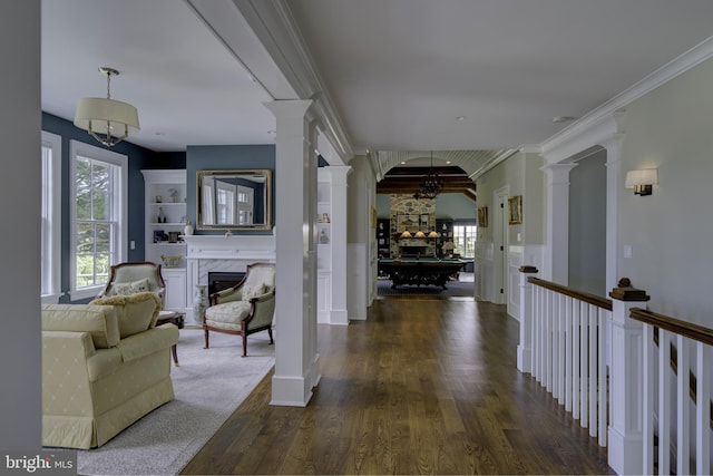 hall featuring crown molding, decorative columns, and dark wood-style flooring