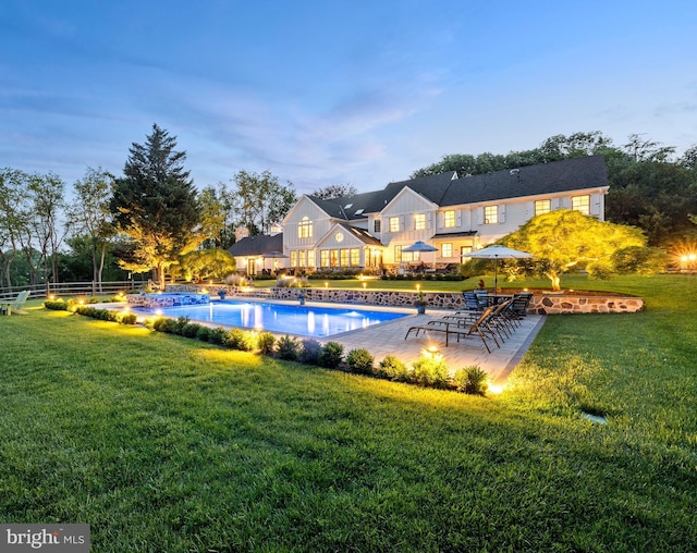 pool featuring a lawn, fence, and a patio area