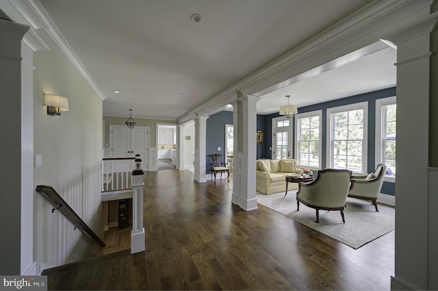 living room featuring baseboards, decorative columns, and wood finished floors