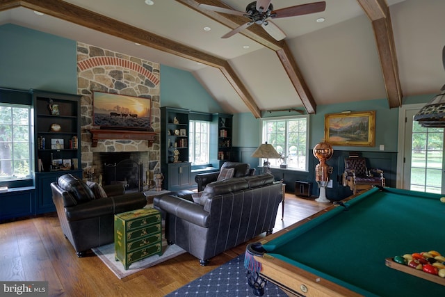 recreation room with ceiling fan, lofted ceiling with beams, a stone fireplace, billiards, and wood finished floors