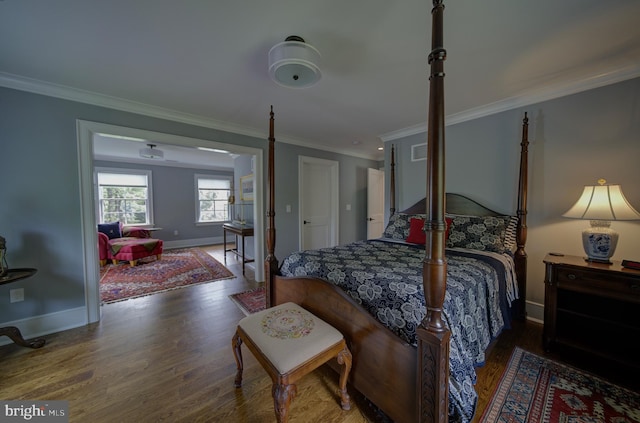 bedroom featuring baseboards, ornamental molding, wood finished floors, and visible vents