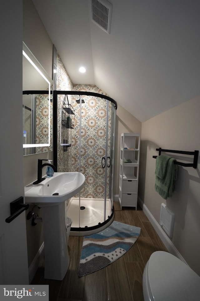 full bathroom with visible vents, wood finish floors, a stall shower, baseboards, and lofted ceiling