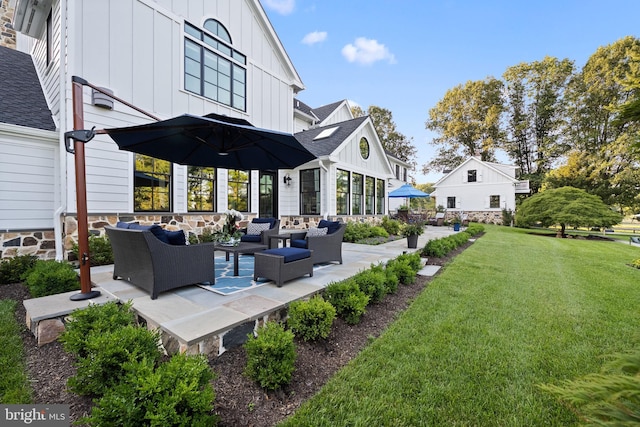 back of house with a patio, roof with shingles, an outdoor hangout area, board and batten siding, and a lawn
