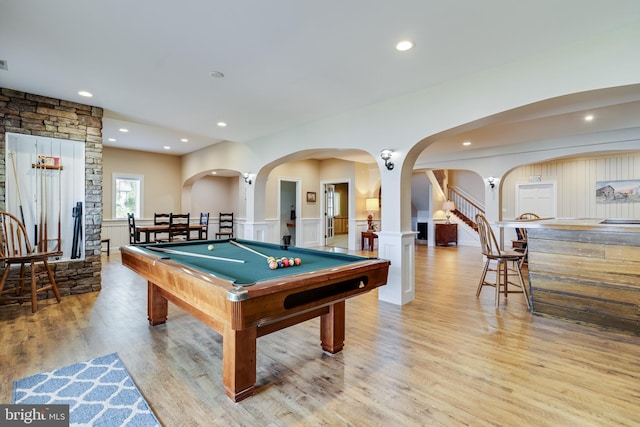 game room featuring billiards, light wood-type flooring, wainscoting, and arched walkways