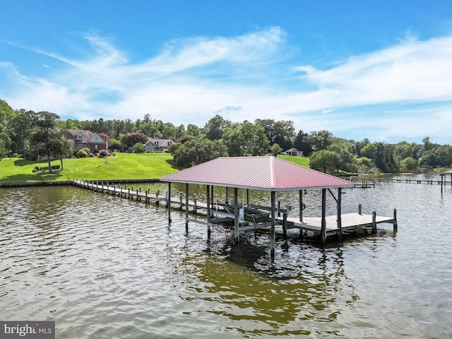 dock area with boat lift, a yard, and a water view
