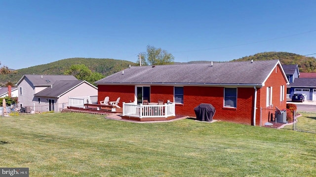 1550 Beacon St, Keyser, WV 26726 - rear view of house with a yard, brick siding, a deck with mountain view, and fence
