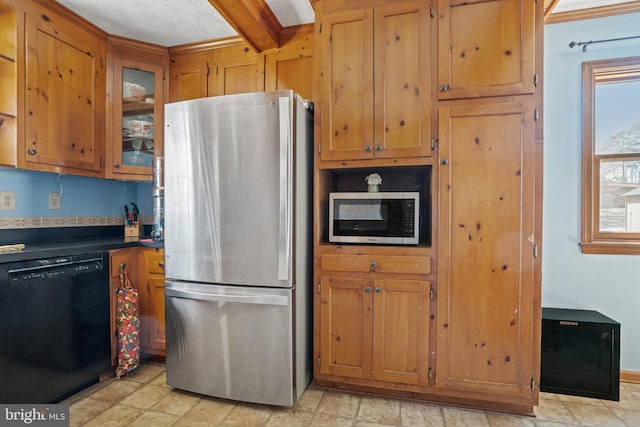 kitchen featuring brown cabinetry, dark countertops, stainless steel appliances, and glass insert cabinets