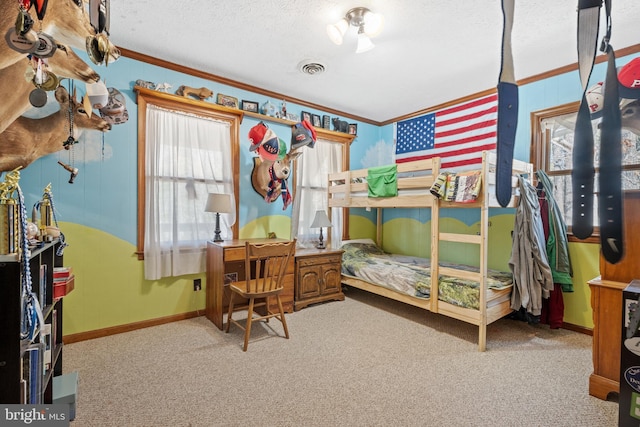 carpeted bedroom with a textured ceiling, baseboards, ornamental molding, and visible vents
