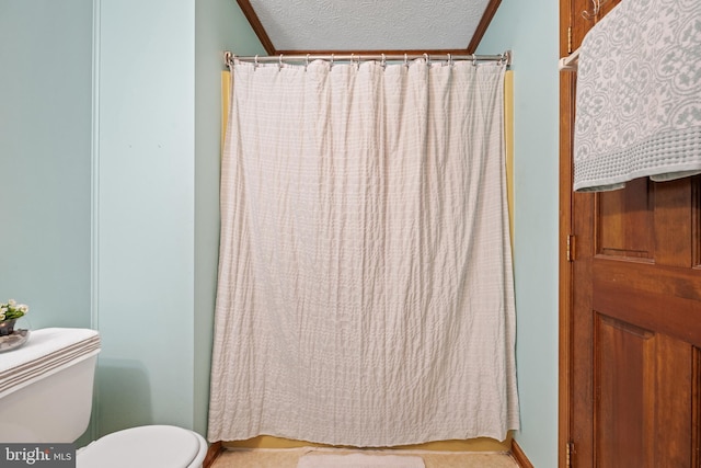 bathroom with baseboards, a shower with curtain, a textured ceiling, and toilet