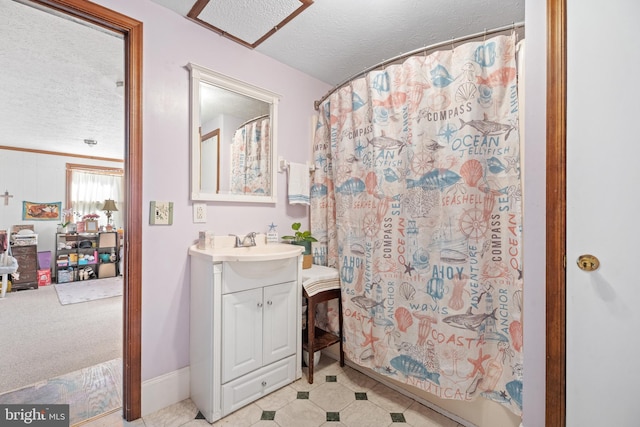 bathroom featuring tile patterned floors, baseboards, vanity, and a textured ceiling