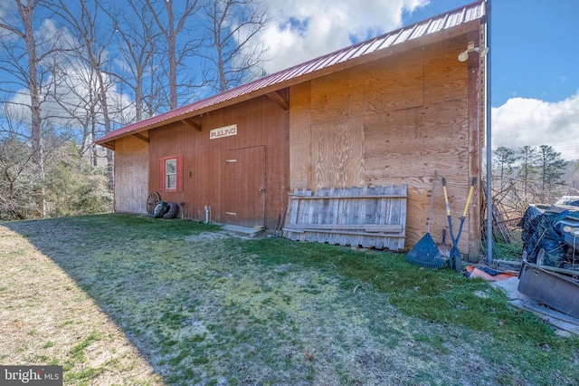 view of side of home with a lawn and metal roof